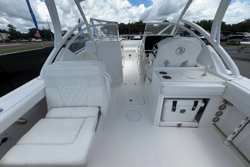 Slide: The Image of 2023 Edgewater 248CX Crossover boat interior with white seating and helm station. - 17