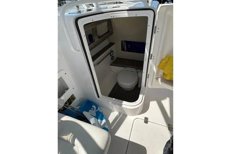 Slide: The Image of 2023 Edgewater 248CX Crossover boat interior with compact marine toilet. - 22