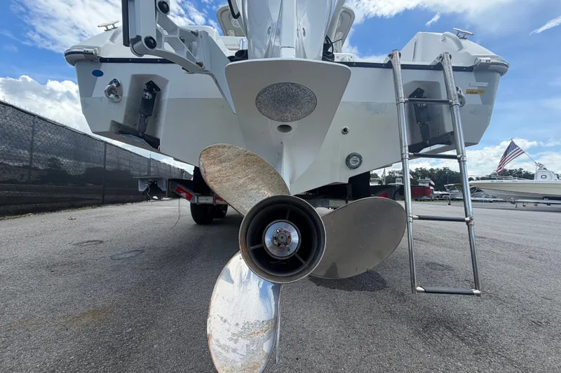 Slide: The Image of 2023 Edgewater 248CX Crossover boat stern with propeller and ladder, parked outdoors. - 4