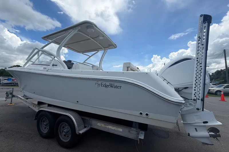 Slide: The Image of 2023 Edgewater 248CX Crossover boat on trailer under cloudy sky. - 7