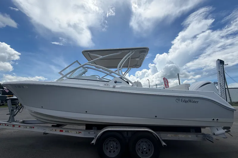 Slide: The Image of 2023 Edgewater 248CX Crossover boat on trailer under a cloudy sky. - 8