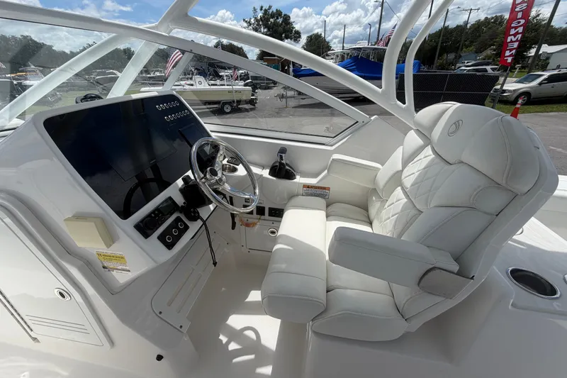 Slide: The Image of 2023 Edgewater 248CX Crossover boat interior with luxurious white seating and modern dashboard. - 35