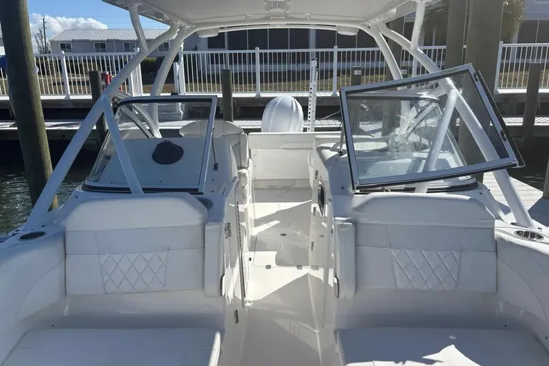 Slide: The Image of 2023 Edgewater 248CX Crossover boat interior with white seating and open windshield. - 23