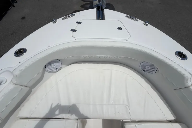 Slide: The Image of 2023 Edgewater 248CX Crossover boat interior with white seating and built-in speakers. - 62