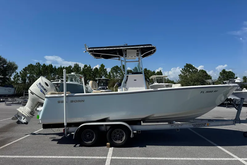 Slide: The Image of 2017 Sea Born LX22 Center Console boat on trailer, parked outdoors under clear blue sky. - 1