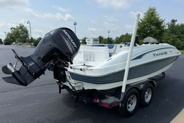 Slide: The Image of 2017 Tahoe 1950 boat on trailer with Mercury outboard motor in parking lot. - 2