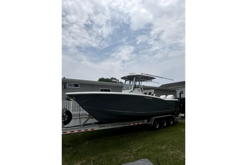 The Image of 2022 Tidewater 282 CC Adventure boat on trailer, parked outdoors under cloudy sky. - 0