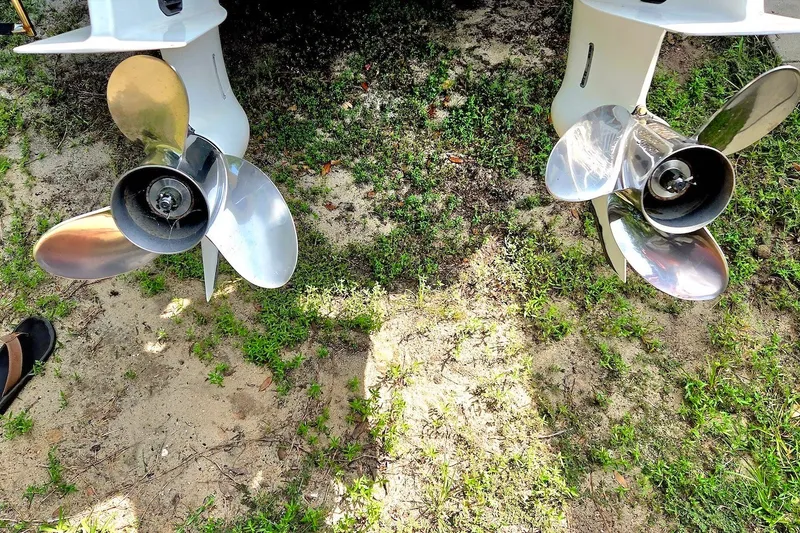 Slide: The Image of Twin propellers of a 2022 Tidewater 282 CC Adventure boat on grassy ground. - 22