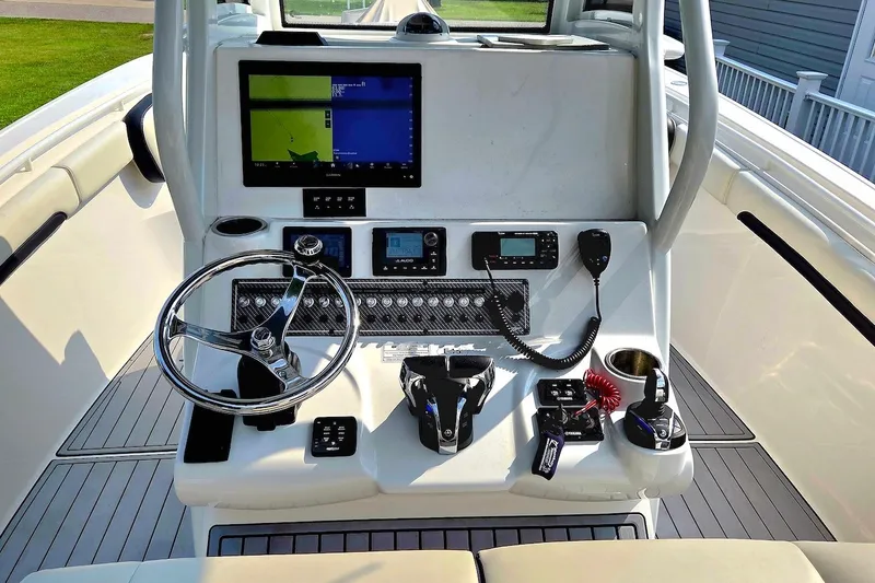 Slide: The Image of 2022 Tidewater 282 CC Adventure boat dashboard with steering wheel and navigation controls. - 14