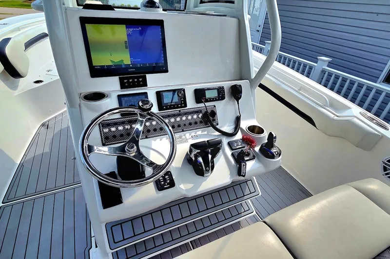 Slide: The Image of 2022 Tidewater 282 CC Adventure boat dashboard with steering wheel and navigation controls. - 16