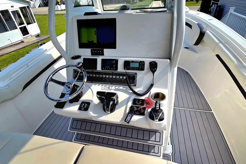 Slide: The Image of 2022 Tidewater 282 CC Adventure boat cockpit with steering wheel and control panel. - 15