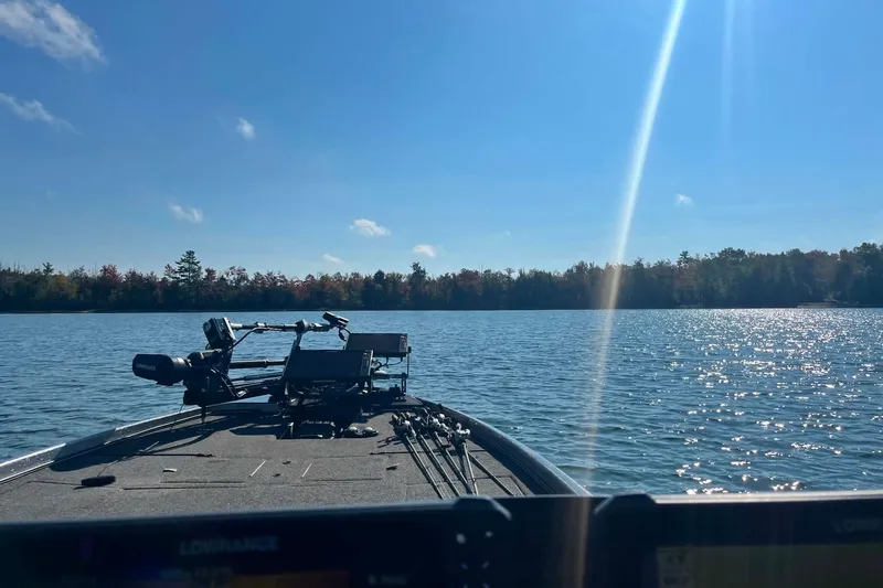 Slide: The Image of 2022 Nitro Z21 XL boat on a serene lake under a clear blue sky. - 17