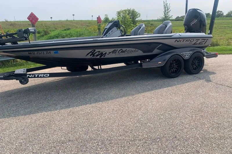 Slide: The Image of 2022 Nitro Z21 XL boat on trailer, parked on a road with grassy background. - 4