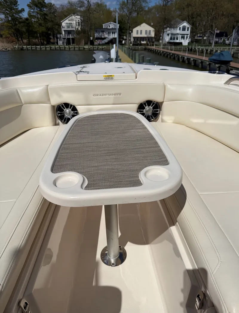 Slide: The Image of The image shows the bow area of a Grady-White Freedom 275 boat with a table and cup holders. - 19