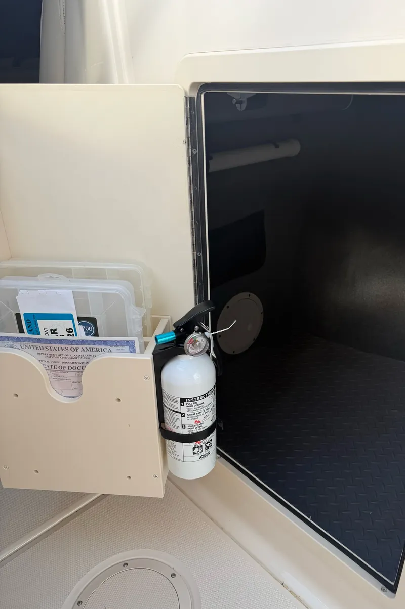 Slide: The Image of An open storage compartment with a fire extinguisher and document holder on the door. - 23