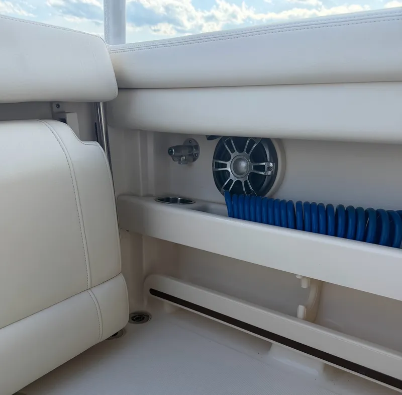 Slide: The Image of Interior of a Grady-White Freedom 275 boat with white upholstery and blue hose storage. - 25