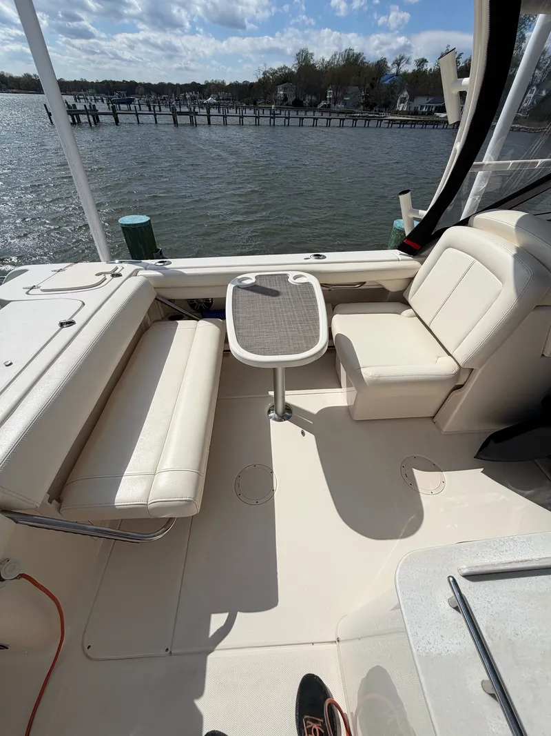 Slide: The Image of The image shows the cockpit of a 2022 Grady-White Freedom 275 with beige seating and a table. - 17