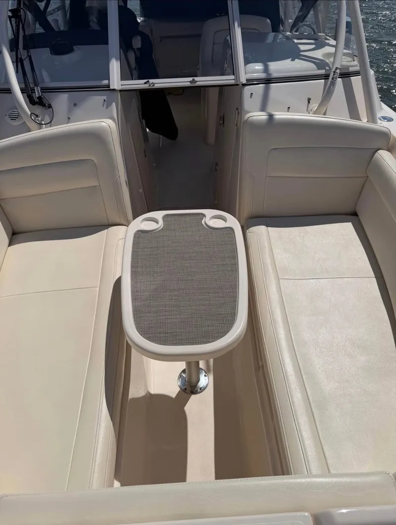 Slide: The Image of The image shows the interior of a 2022 Grady-White Freedom 275 boat with beige seating and a table. - 14