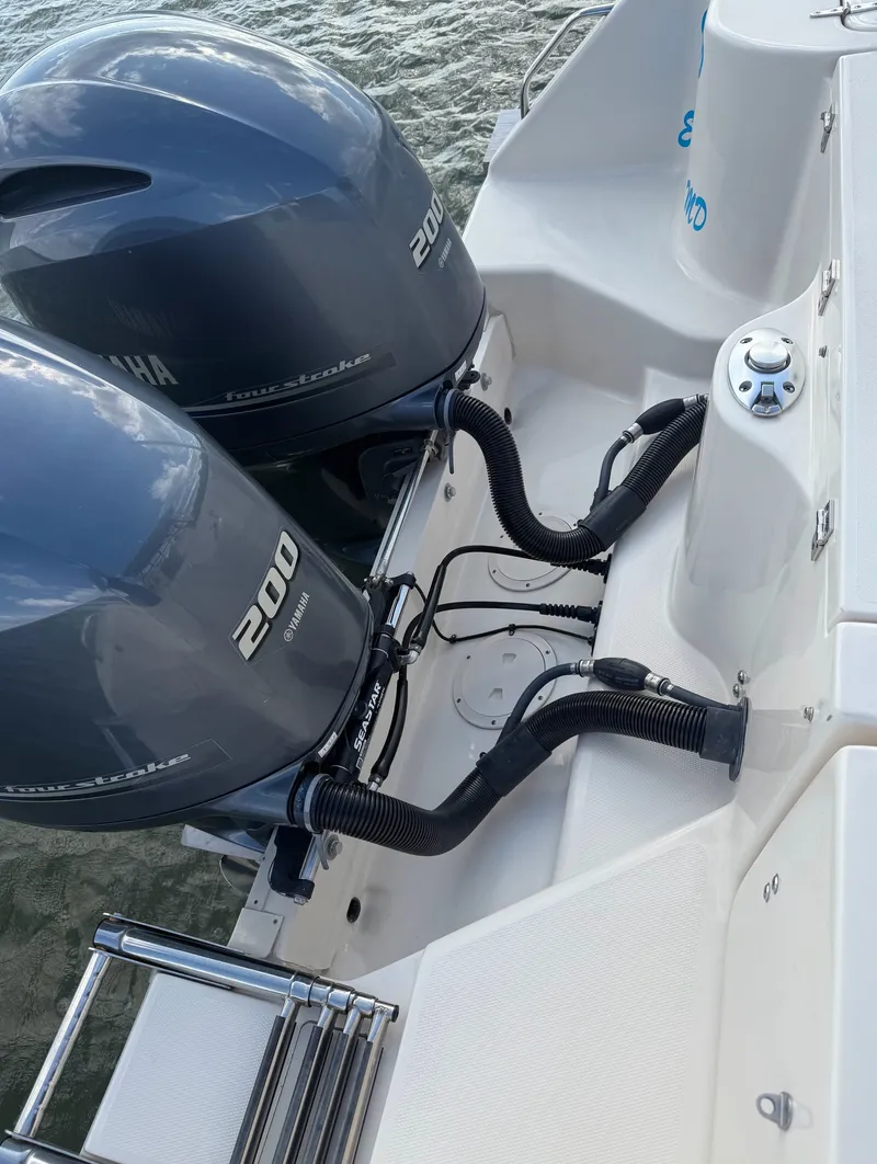 Slide: The Image of Two outboard engines on a boat, with a swim ladder and control station nearby. - 24