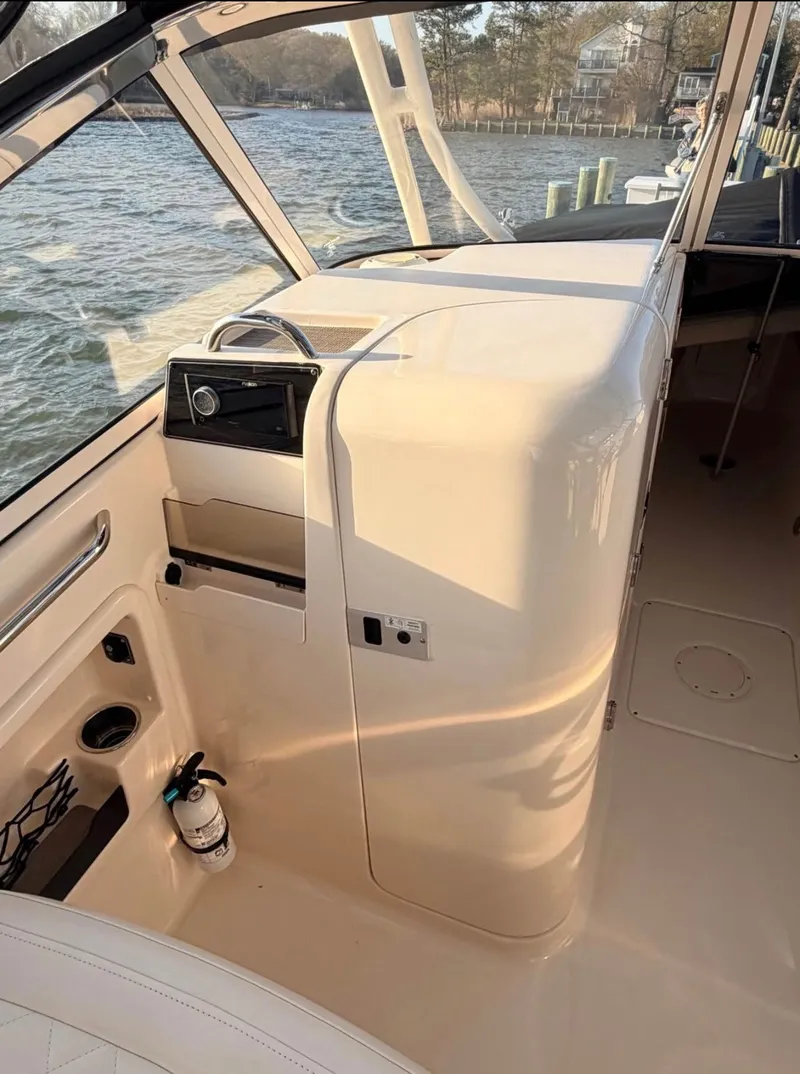 Slide: The Image of The image shows the cockpit of a 2022 Grady-White Freedom 275 with a helm station and fire extinguisher. - 7