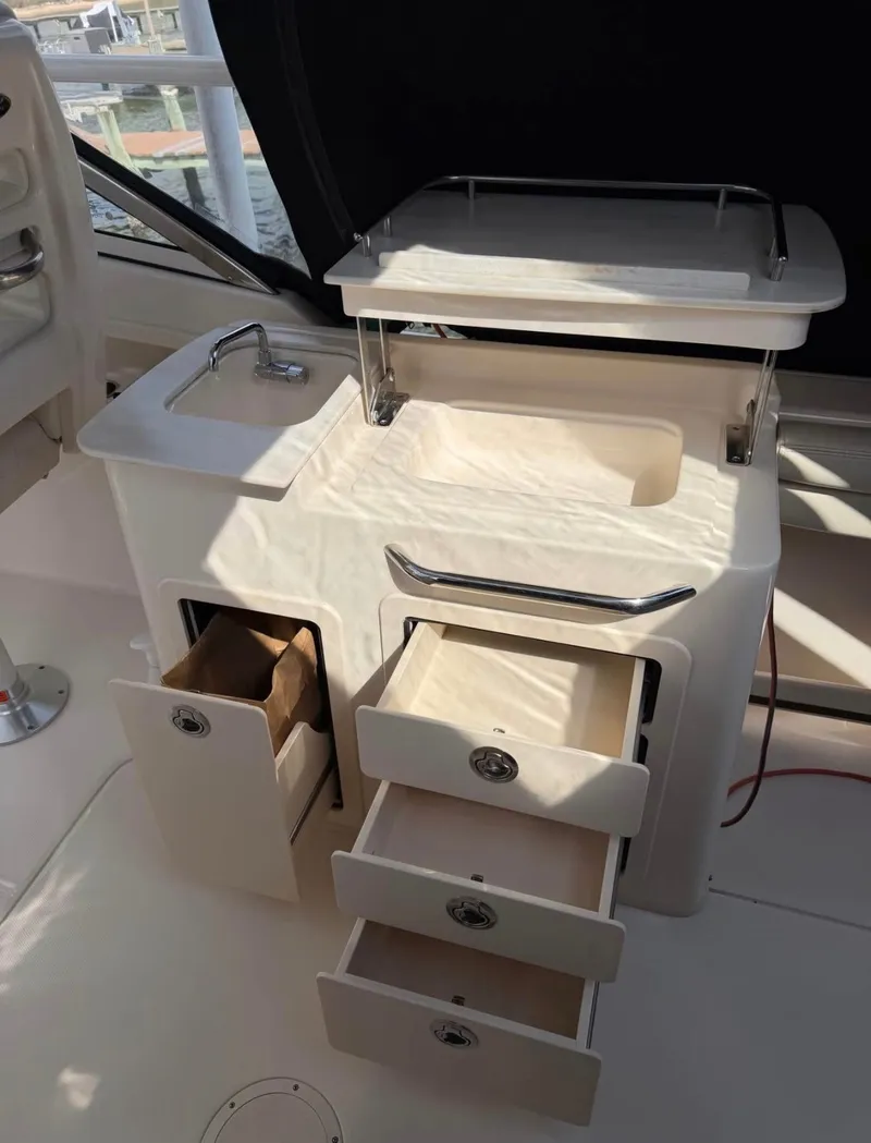 Slide: The Image of The 2022 Grady-White Freedom 275 features a compact galley with a sink and drawers. - 11