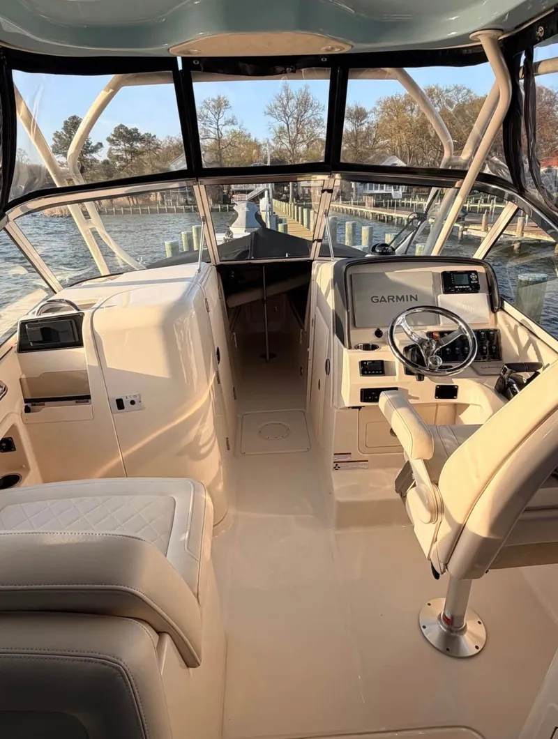 Slide: The Image of The cockpit of a 2022 Grady-White Freedom 275 with beige seating and a Garmin navigation system. - 3