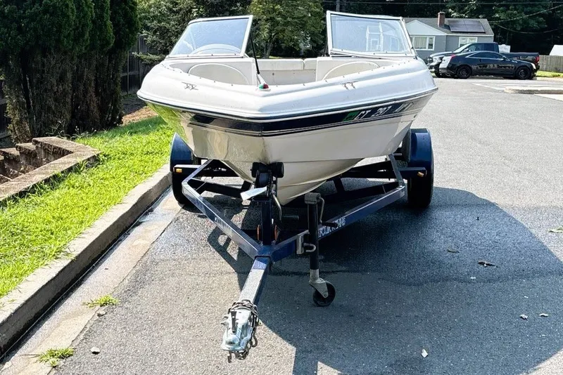 Slide: The Image of 1997 Four Winns 170 Horizon boat on trailer, parked on a residential street. - 8