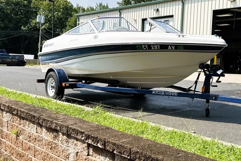 Slide: The Image of 1997 Four Winns 170 Horizon boat on trailer, parked outdoors near a building. - 6