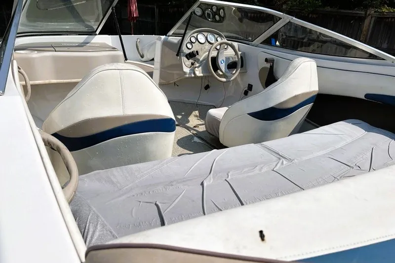 Slide: The Image of Interior of a 1997 Four Winns 170 Horizon boat, featuring white and blue seating. - 9