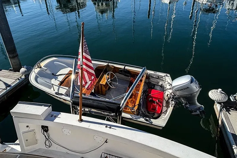 Slide: The Image of Small boat docked with American flag and Honda outboard motor, Sabreline 47, 2000 model. - 17