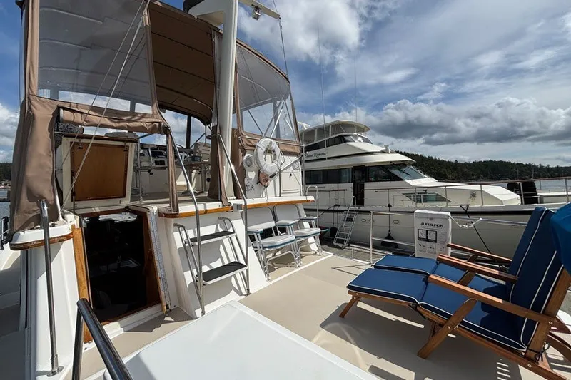 Slide: The Image of 2000 Sabreline 47 yacht with deck seating and canopy, docked beside another boat. - 20