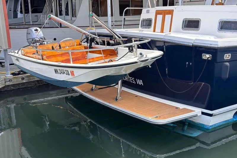 Slide: The Image of 2000 Sabreline 47 yacht with a small boat on the stern platform, docked in a marina. - 19