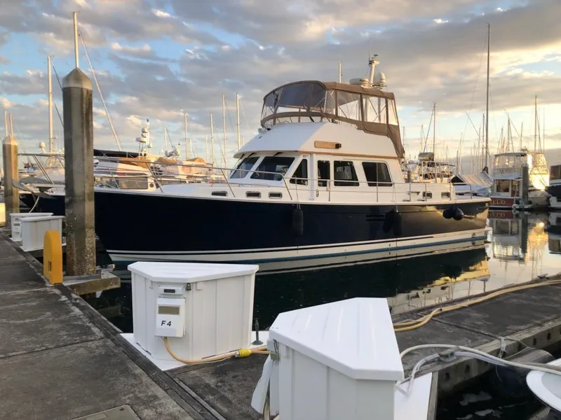 Slide: The Image of A 2000 Sabreline 47 docked at a marina. The sky is cloudy. - 2