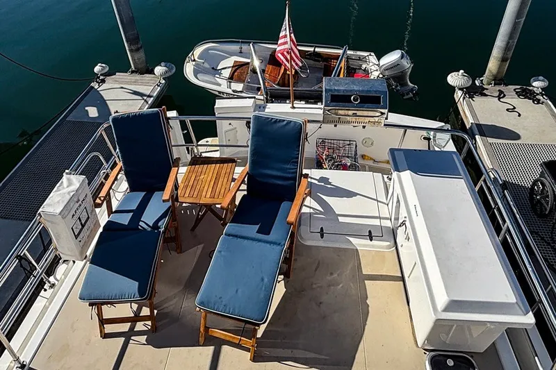 Slide: The Image of Deck of 2000 Sabreline 47 yacht with lounge chairs and small boat. - 23