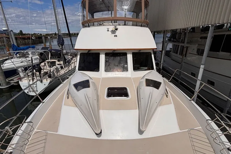 Slide: The Image of 2000 Sabreline 47 yacht docked, showcasing spacious deck and sleek design. - 21
