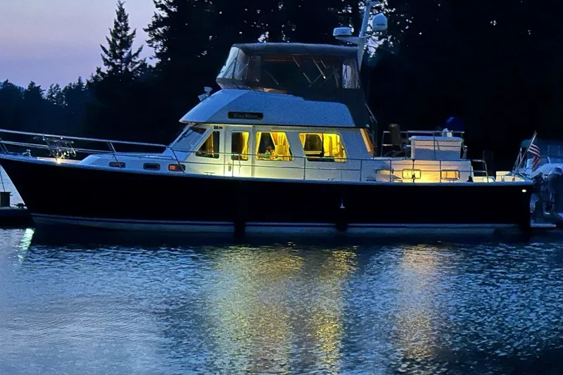 The Image of 2000 Sabreline 47 yacht illuminated at dusk on calm water. - 0