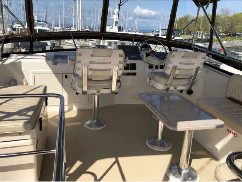 Slide: The Image of The cockpit of a 2000 Sabreline 47 with two white captain's chairs and a table. - 4
