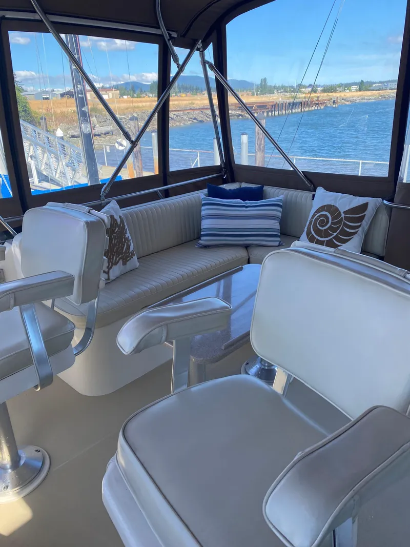 Slide: The Image of Interior of a 2000 Sabreline 47 with white seating and decorative pillows. - 9