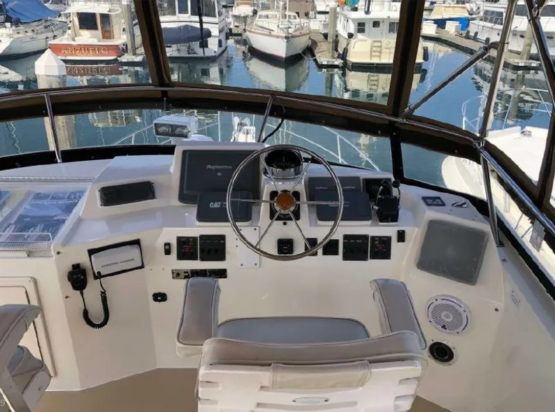 Slide: The Image of The cockpit of a 2000 Sabreline 47 with steering wheel, instruments, and a marina view. - 8