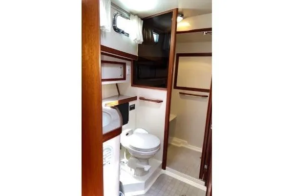 Slide: The Image of Interior of 2000 Sabreline 47 yacht bathroom with toilet, sink, and wooden accents. - 32