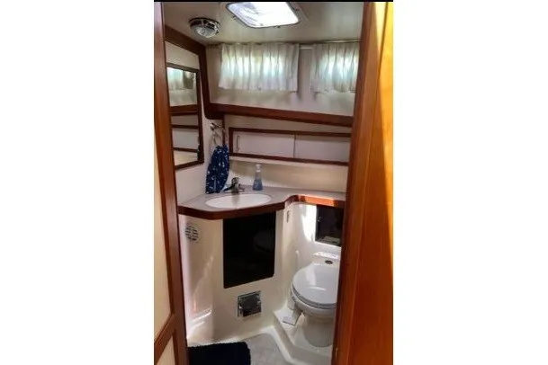 Slide: The Image of Bathroom interior of 2000 Sabreline 47 yacht with sink, toilet, and wooden accents. - 28