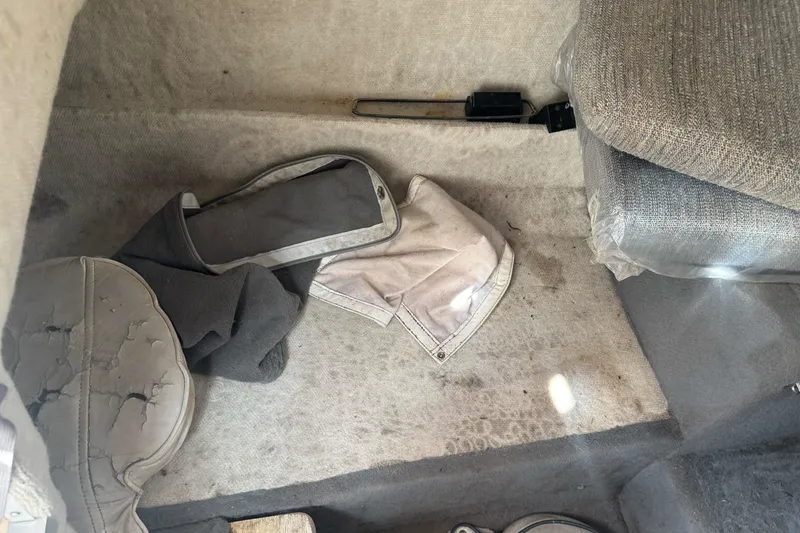 Slide: The Image of Interior of a 1995 Bayliner 2302 Trophy Walkaround with worn upholstery and scattered items. - 19