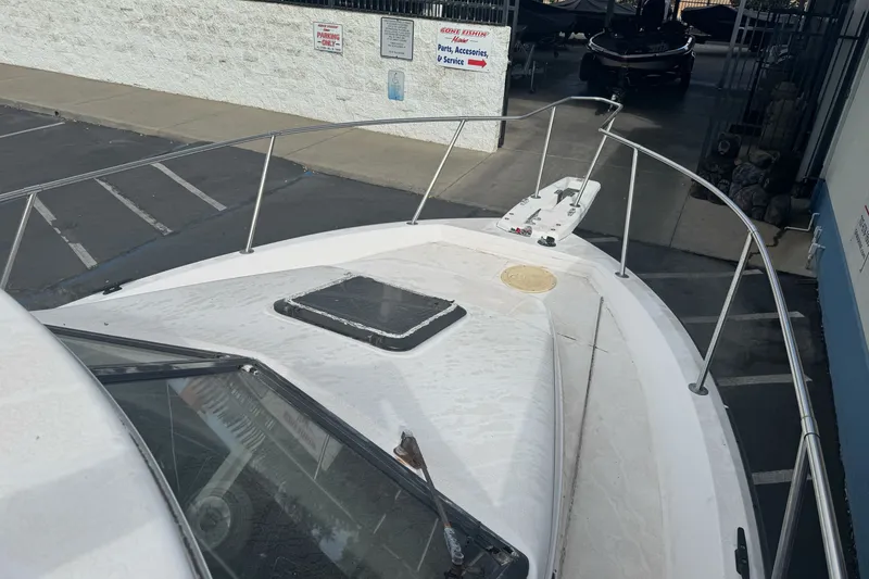 Slide: The Image of 1995 Bayliner 2302 Trophy Walkaround boat docked, showcasing bow and deck features. - 27