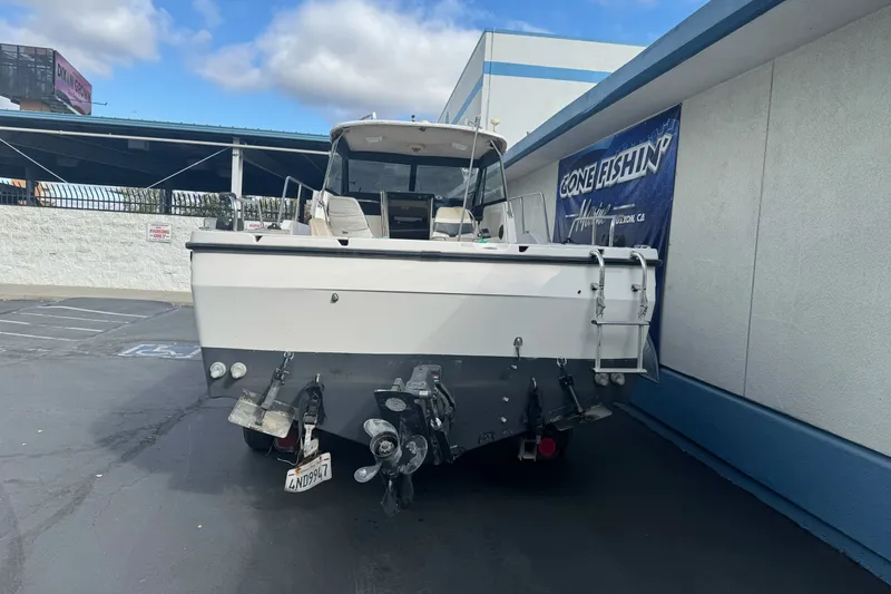 Slide: The Image of 1995 Bayliner 2302 Trophy Walkaround boat parked at a marina, rear view. - 6