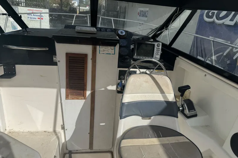 Slide: The Image of Interior of a 1995 Bayliner 2302 Trophy Walkaround boat showing steering and control panel. - 23