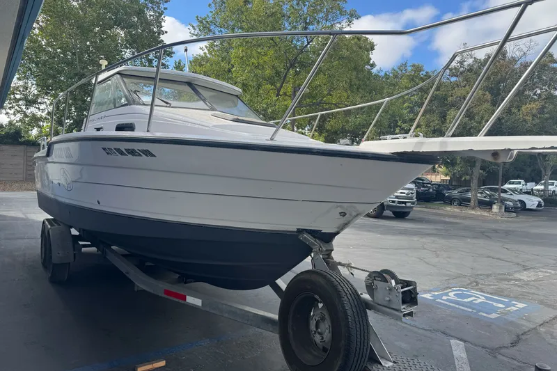 Slide: The Image of 1995 Bayliner 2302 Trophy Walkaround boat on trailer in parking lot. - 3
