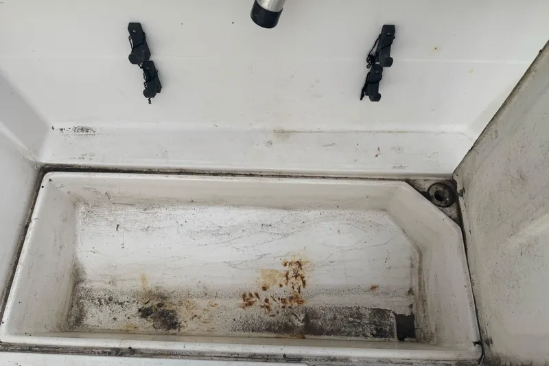 Slide: The Image of 1995 Bayliner 2302 Trophy Walkaround boat storage compartment, showing wear and dirt. - 25