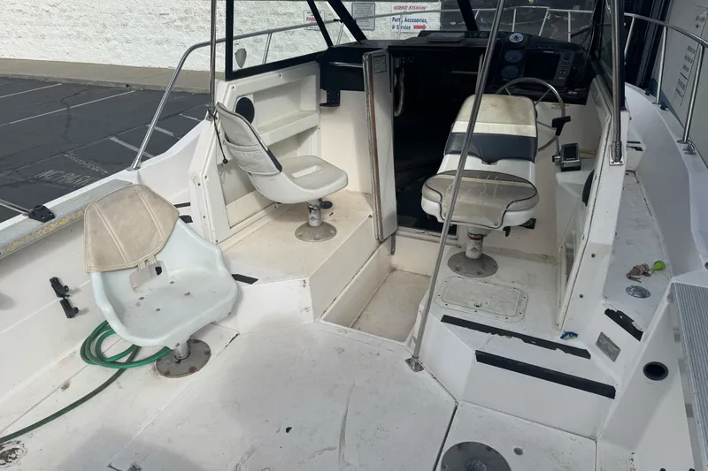 Slide: The Image of 1995 Bayliner 2302 Trophy Walkaround boat interior with seating and steering area. - 9