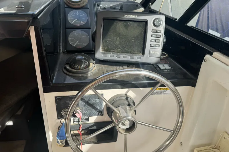 Slide: The Image of 1995 Bayliner 2302 Trophy Walkaround dashboard with steering wheel and navigation equipment. - 15