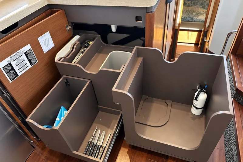 Slide: The Image of Interior storage compartments on a 2014 Sea Ray 510 Fly yacht, featuring organized kitchen utilities. - 9